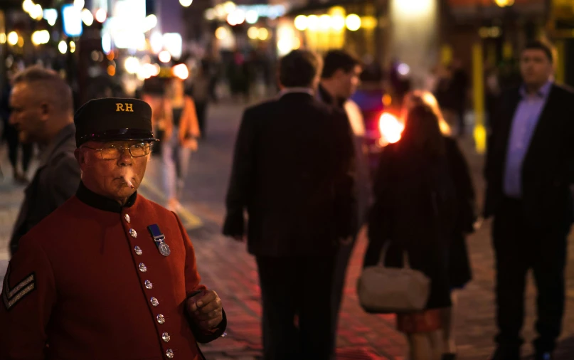 an old man is standing in the middle of a busy street