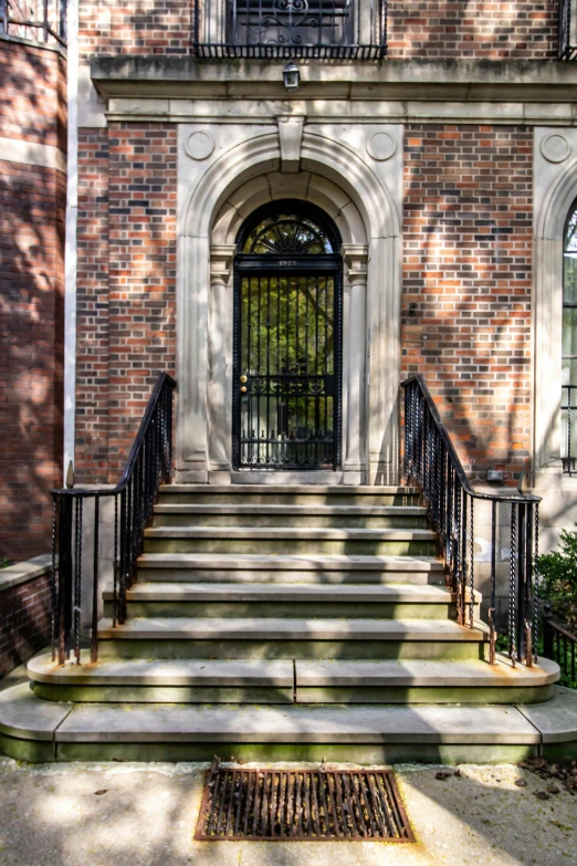 large brick building with ornate iron railing and door