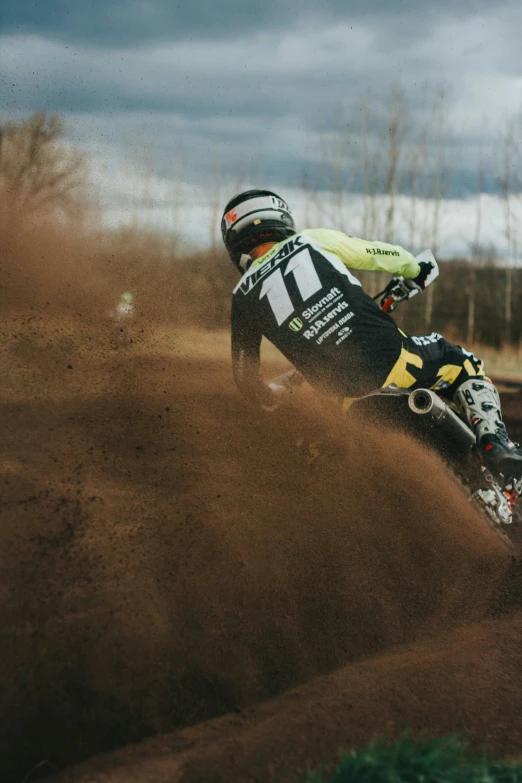 a man rides a dirt bike on the side of a trail