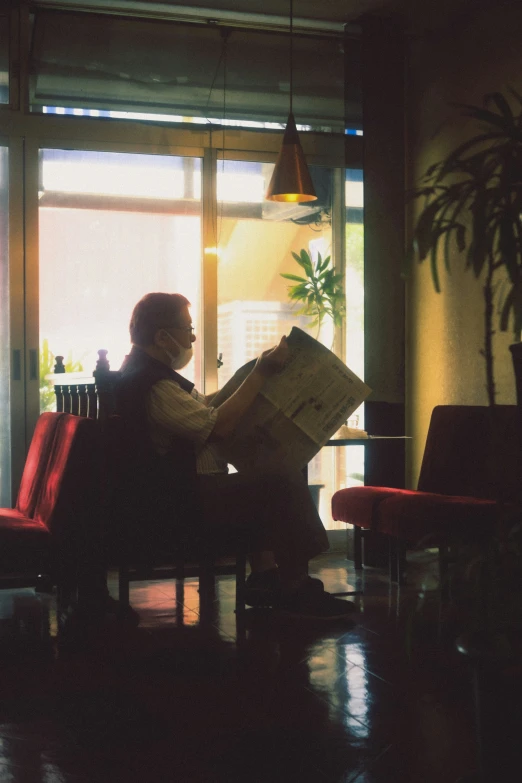 the woman is reading her newspaper in the chair