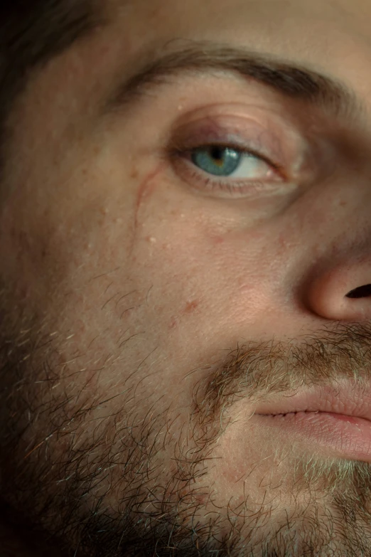 closeup of man's facial with light blue eyes and moustache