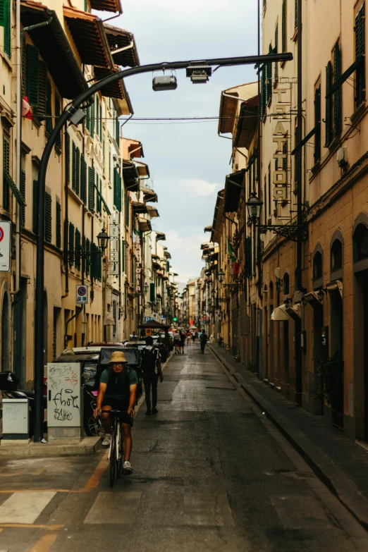 a man riding a bicycle down a long street