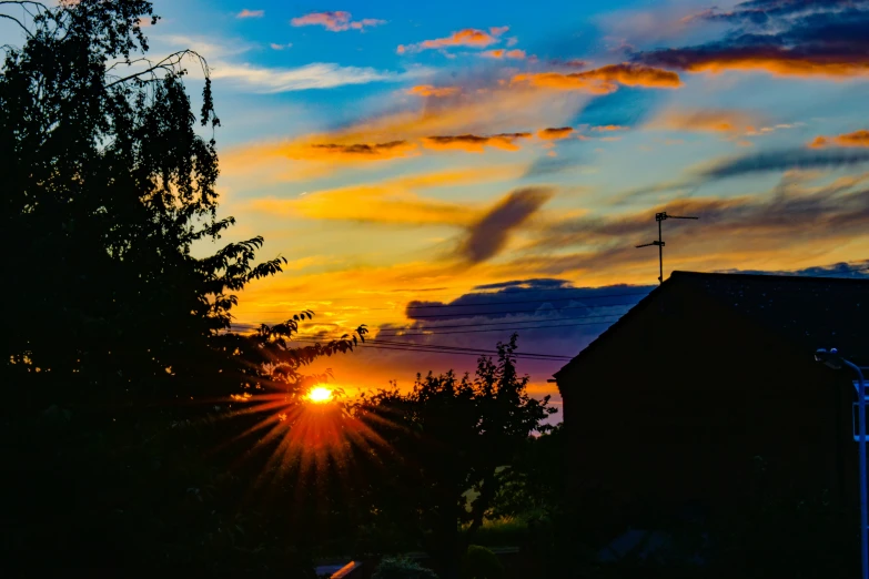 the sun rises above some buildings as seen from a distance