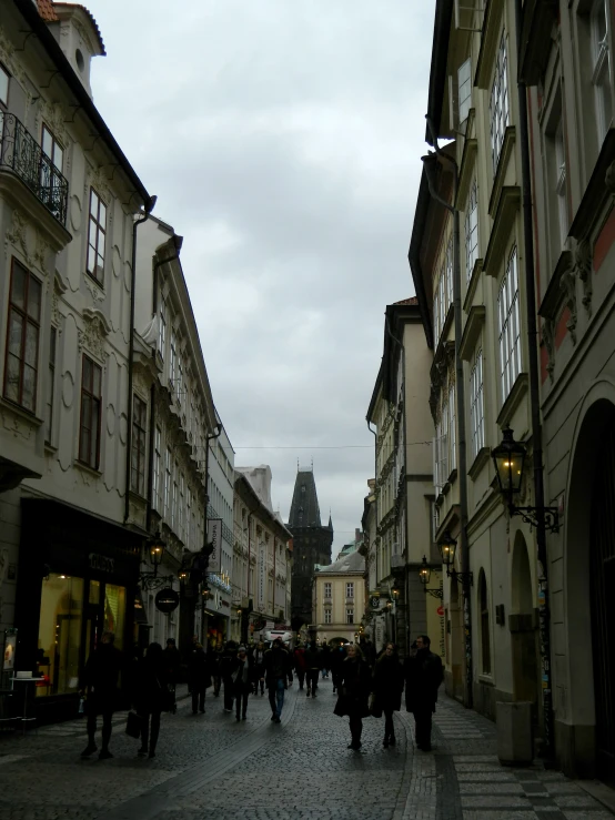 a street scene with people walking on a cobblestone street