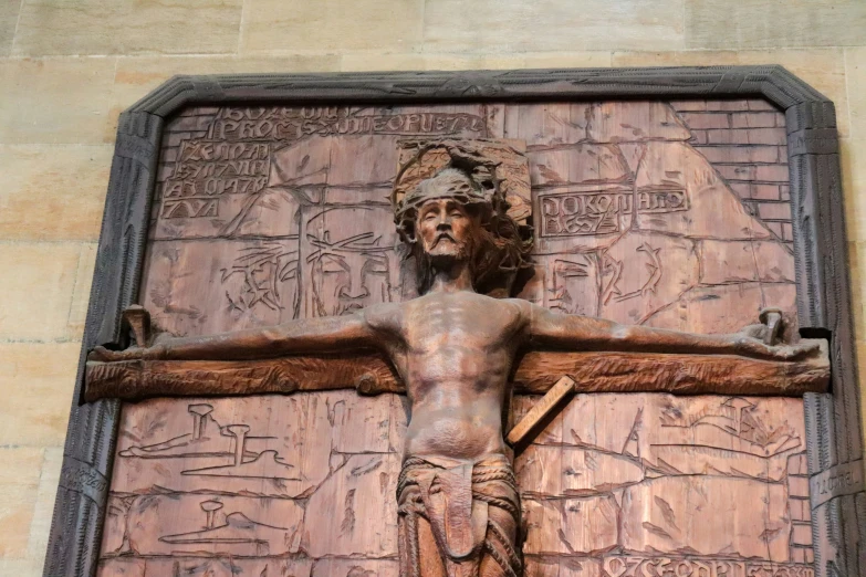 a statue with a wooden carving of jesus on the cross