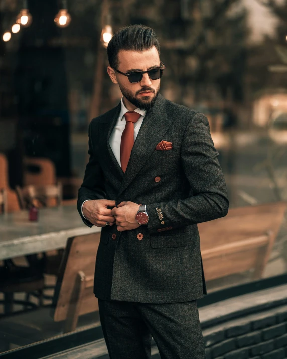 a man in suit and tie is wearing sun glasses