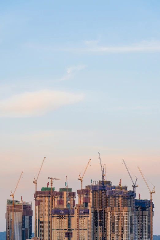 the city skyline has tall buildings, cranes and a clock