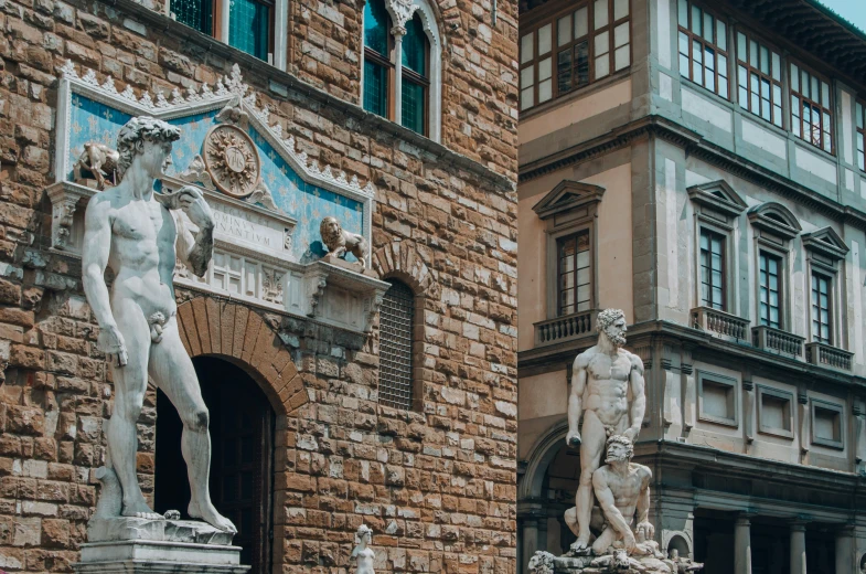 statue statues at the entrance to a large brick building