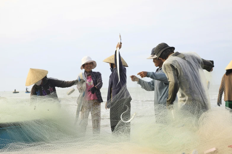 four people standing in the water on their way to a boat