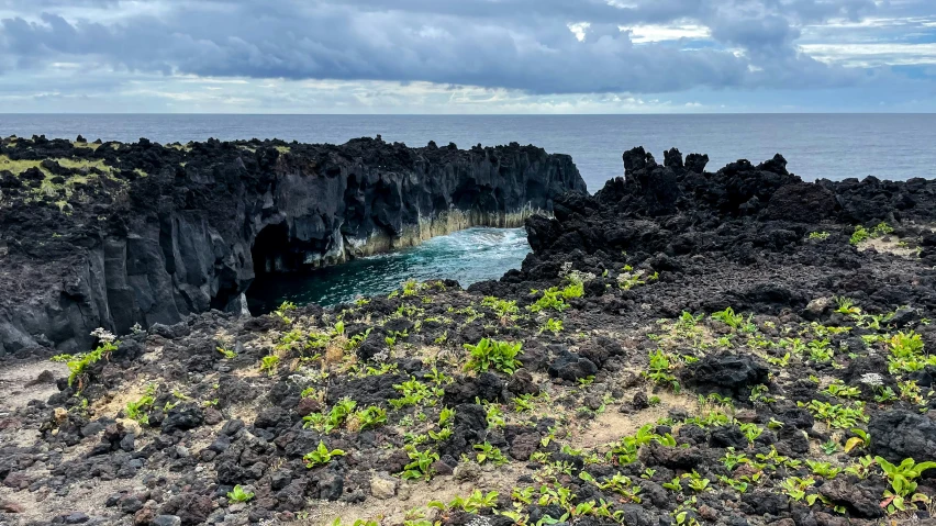 a blue ocean in front of a group of rocky coastline