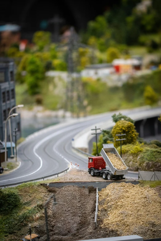 a red truck with a loading ramp on the back is in the middle of the street