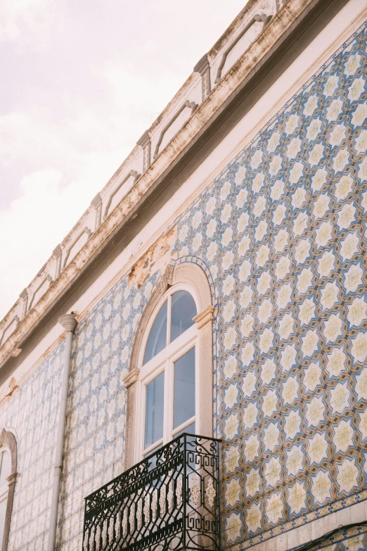 ornate building front with wrought iron balcony