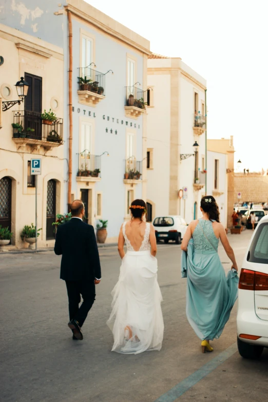 three people walking down the street in dresses