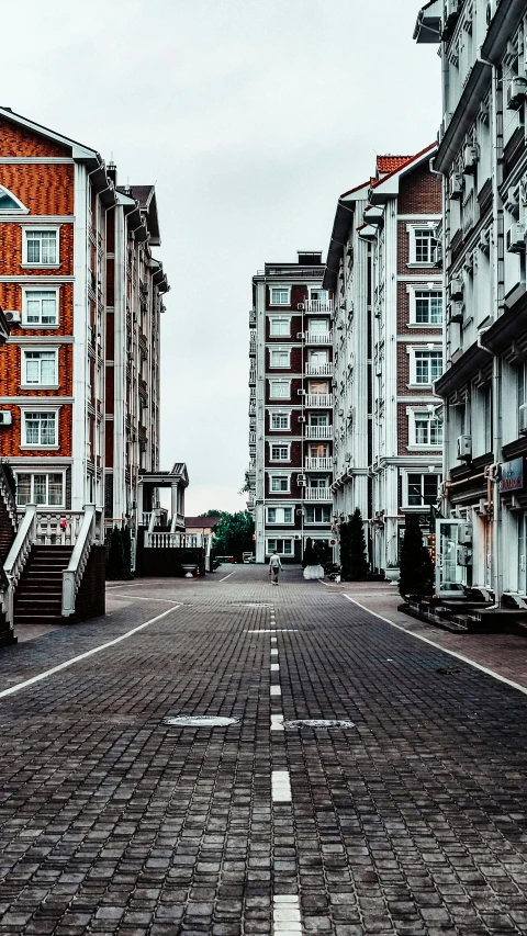 empty brick street with red, white, and orange building