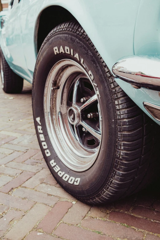 the front tire of a classic blue car