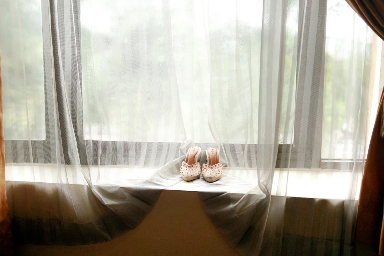 a pair of shoes sits on a ledge next to a window