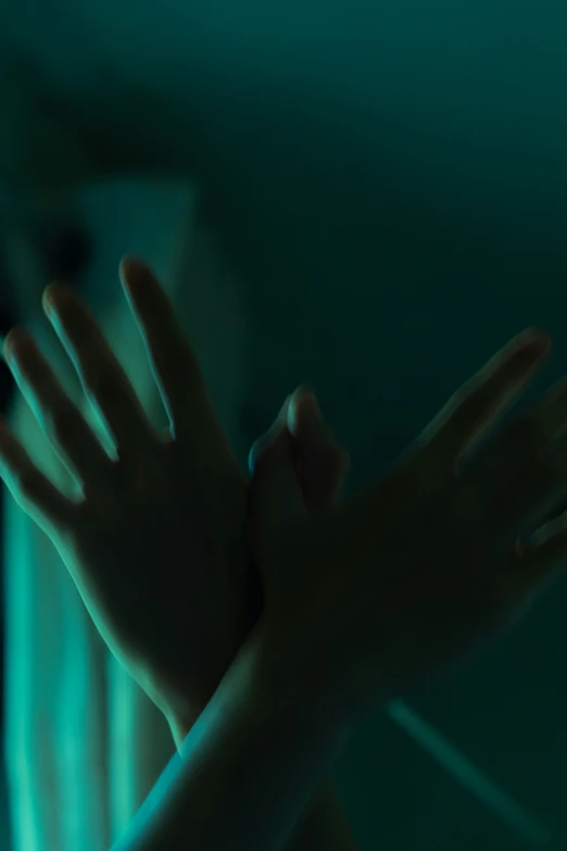 a person in a dimly lit room holds their hand out to the camera