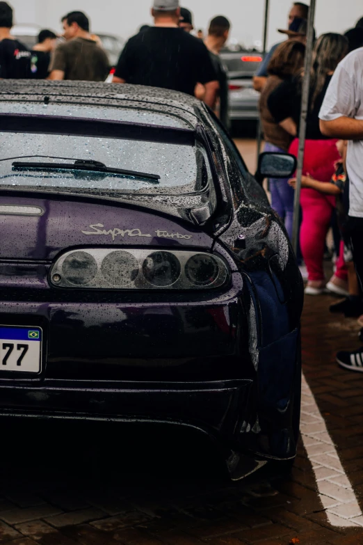 a car parked in front of a crowd of people