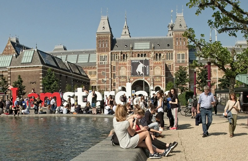 people walking around in the city with large letters in the background