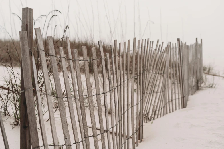 a line of wooden fences that are covered in snow