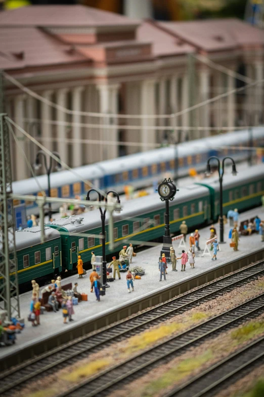 a green passenger train going down some tracks