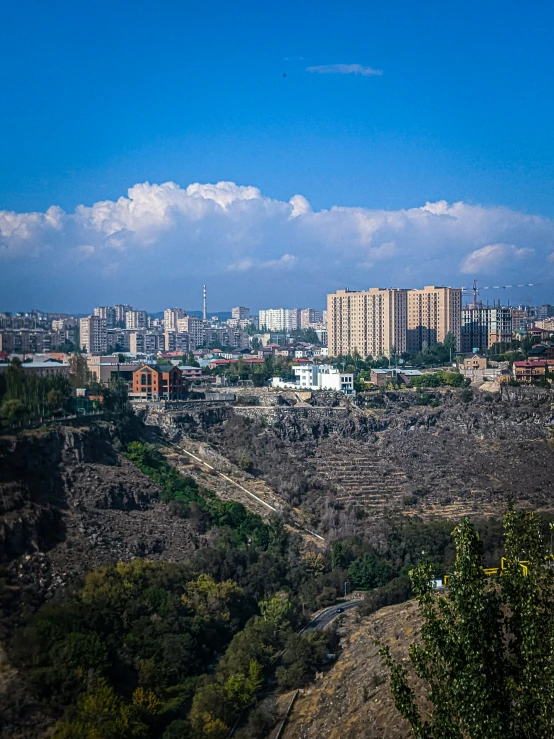 a hill overlooking a city and buildings in the distance