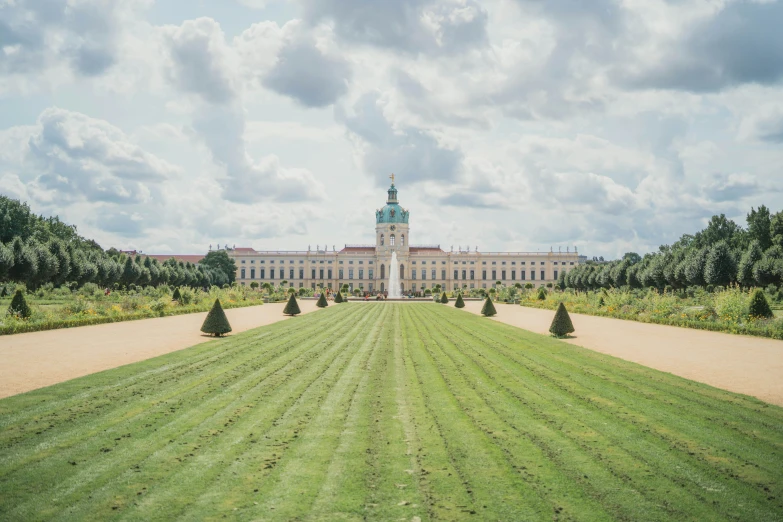 a huge building in a garden with lots of trees