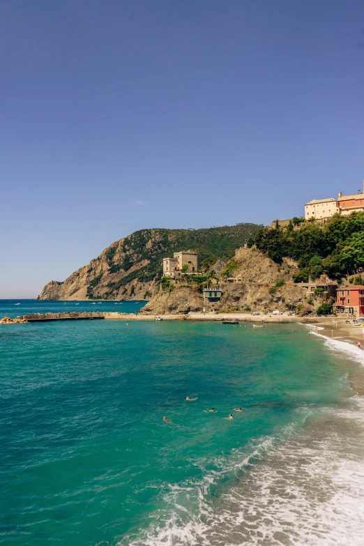 the ocean near a beach and a hill is shown