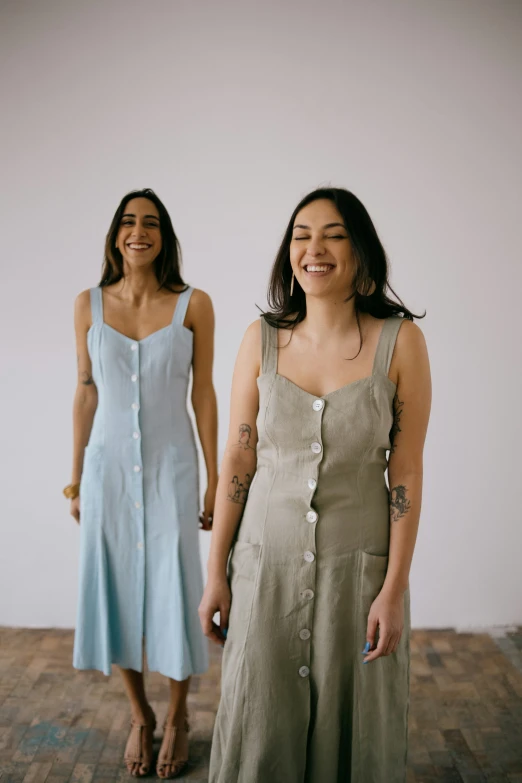 two women in gray and light blue clothing standing next to each other