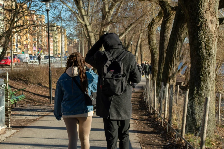 a man standing next to a woman on a sidewalk