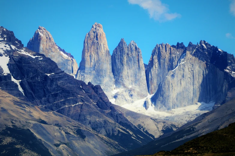 a group of mountains surrounded by snow in a clear sky