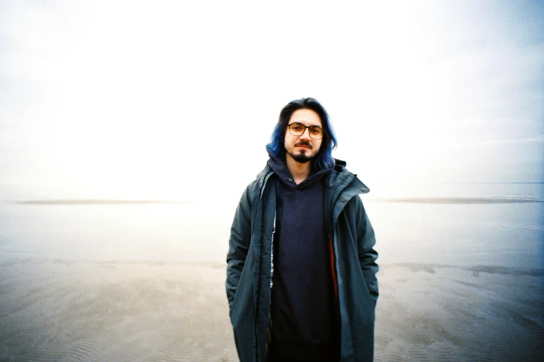 a man is standing on the sand and staring ahead