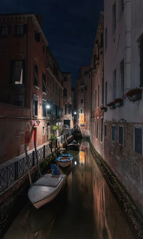 a canal at night next to a row of buildings