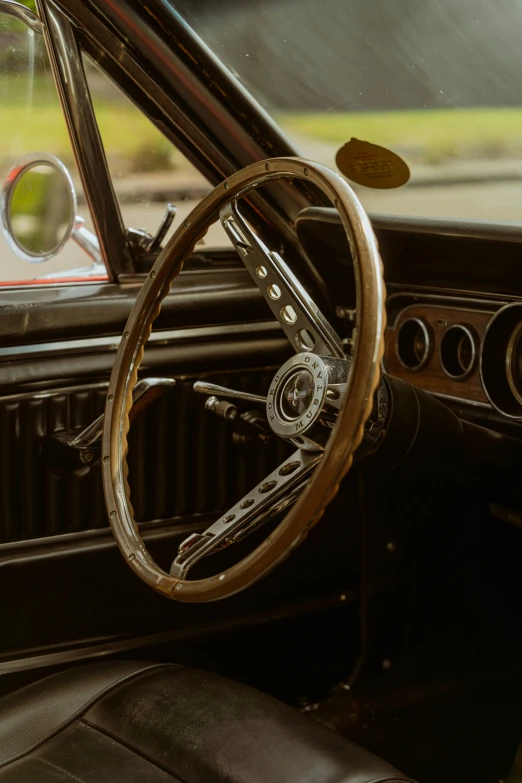 a steering wheel, a leather dash and a steering wheel in the front seat of an old car