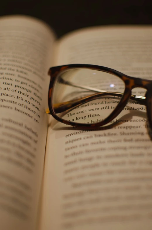 a pair of glasses laying on an open book