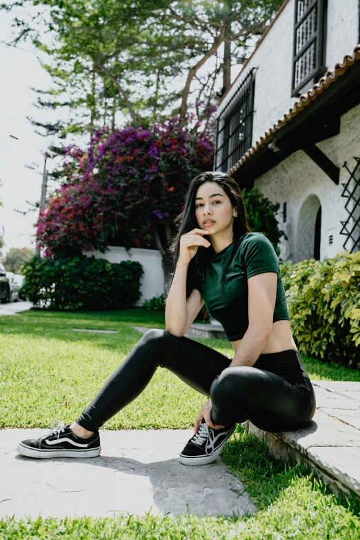 a woman sitting in the grass outside a house