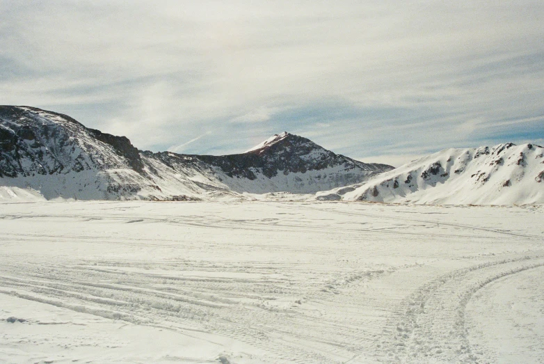 a snow covered landscape with mountains in the background