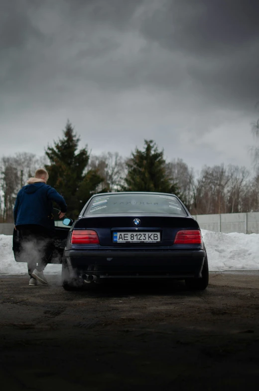 a man standing next to a car on the road