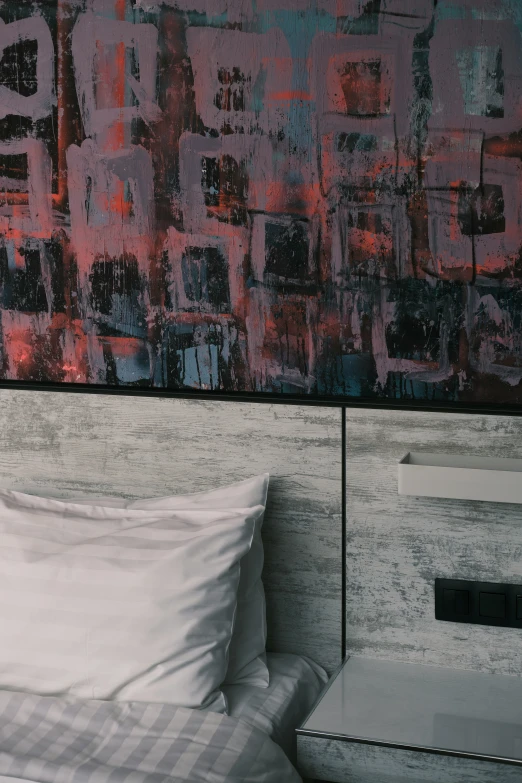 a big painting over a bed that's made up