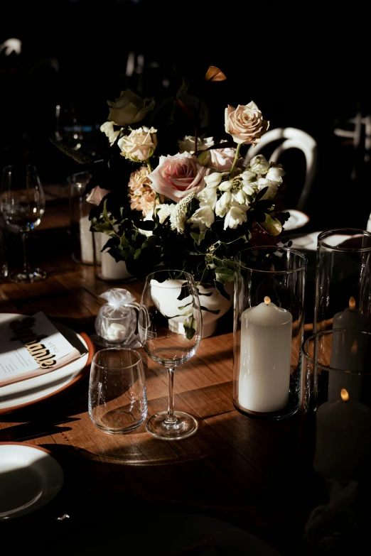 a dinner table has roses and candles in it