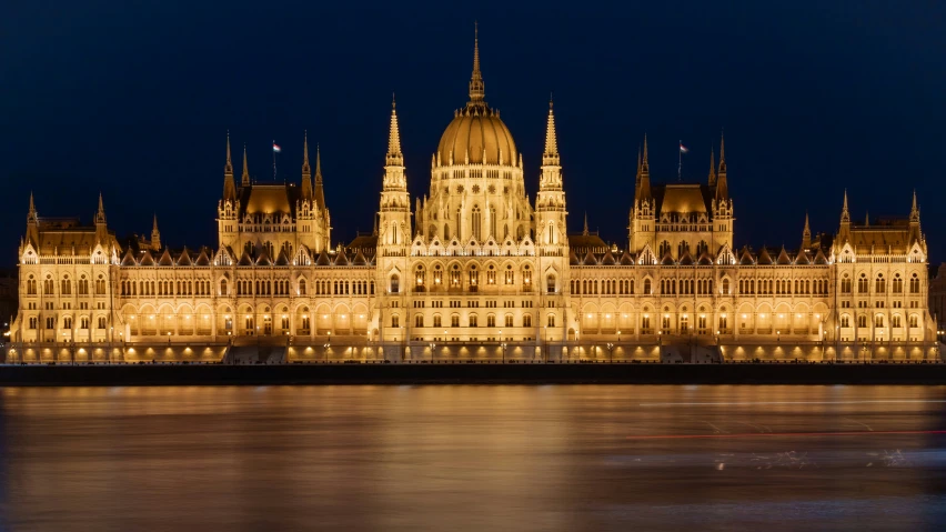 a castle style building with lights reflecting off the water