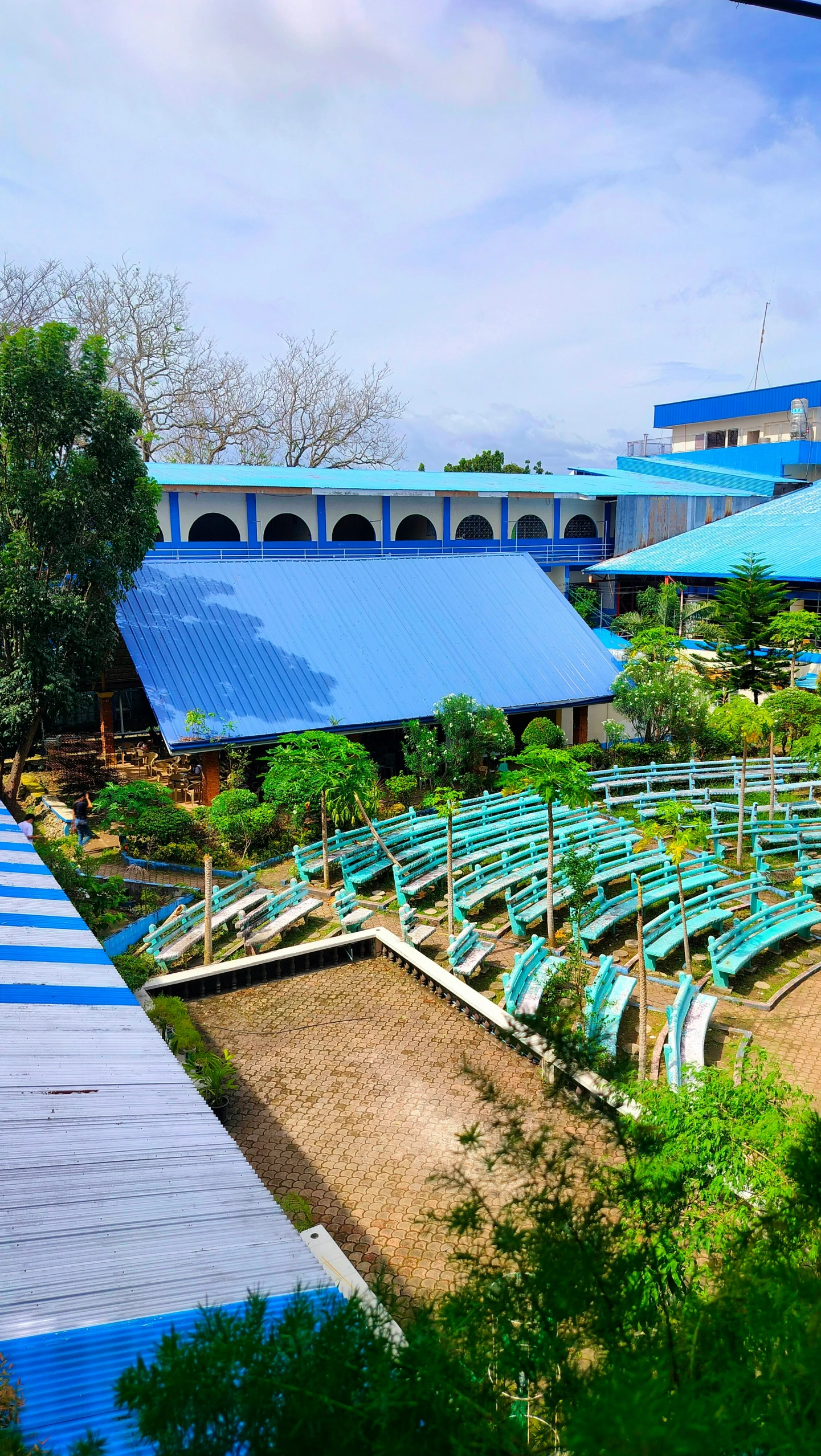 a group of blue benches sitting in the middle of a parking lot