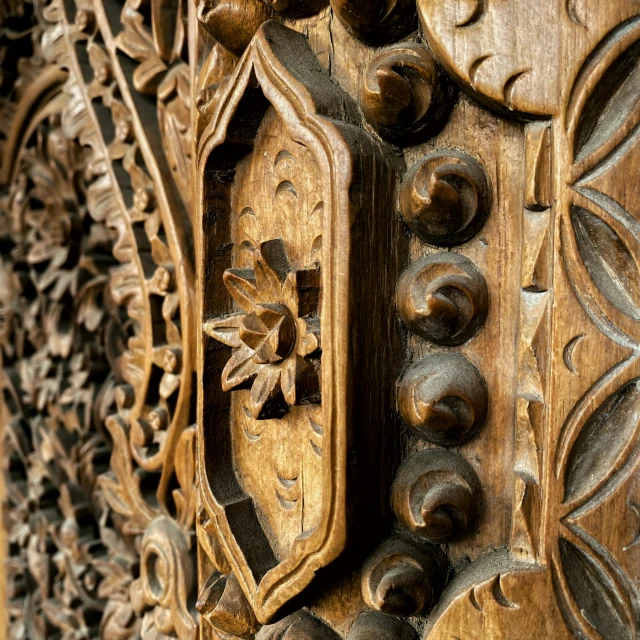 closeup of a carved wood door with decorative designs