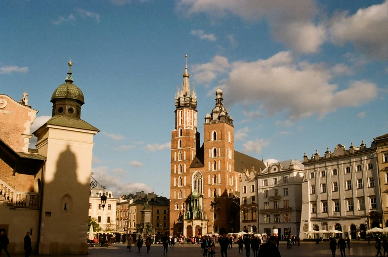 people are walking around a city square with tall buildings