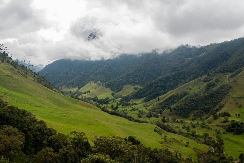 clouds are gathering over a hilly valley