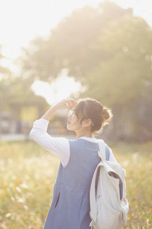 a woman with a backpack looking into the sky