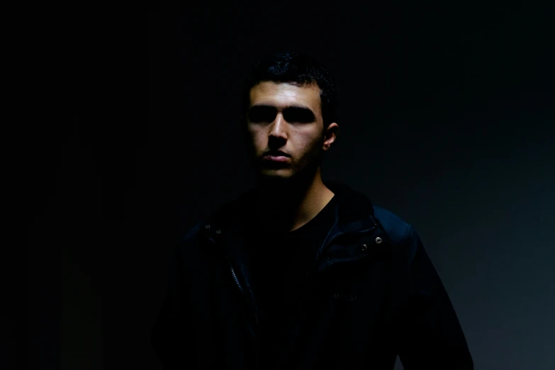 a male with a black shirt and a light in the background