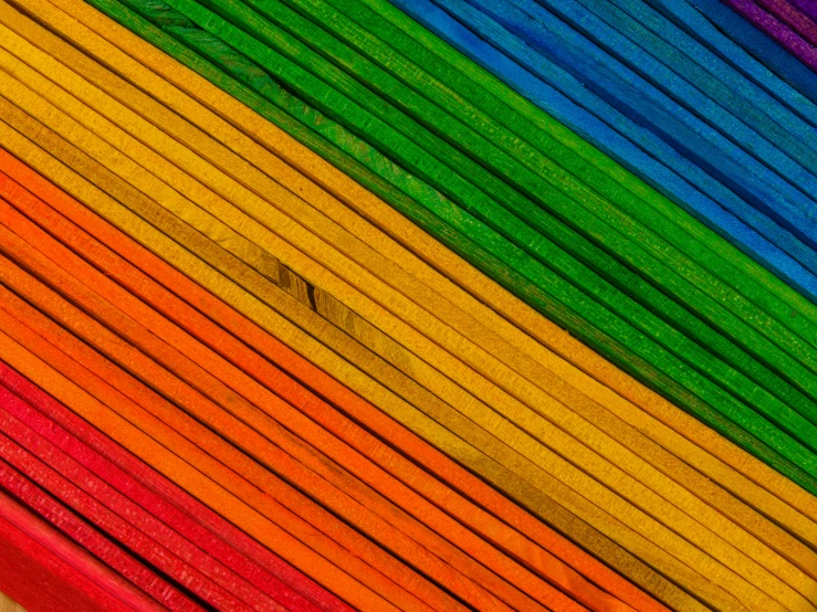 a rainbow colored paper background with wood slats