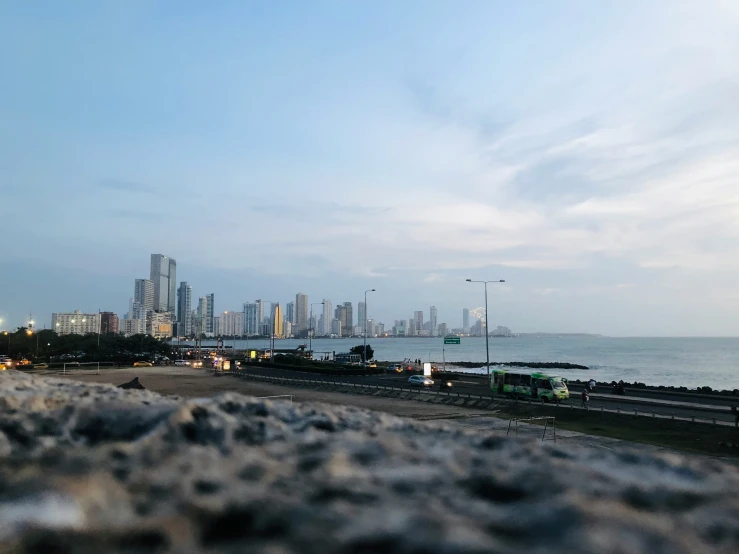 the city skyline is near water at twilight