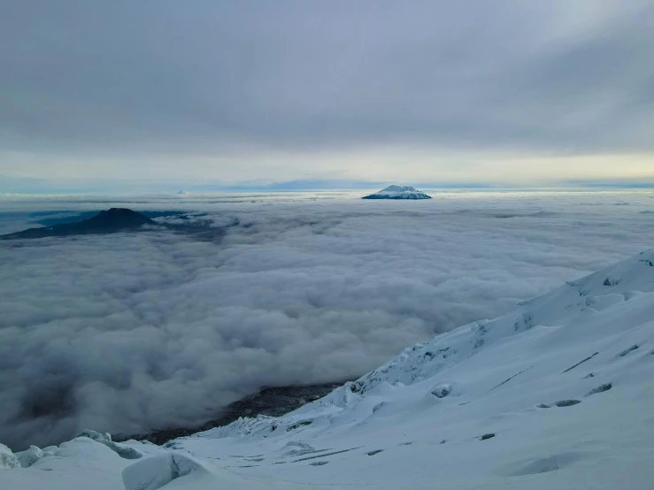 some clouds are hovering over some snow and mountains